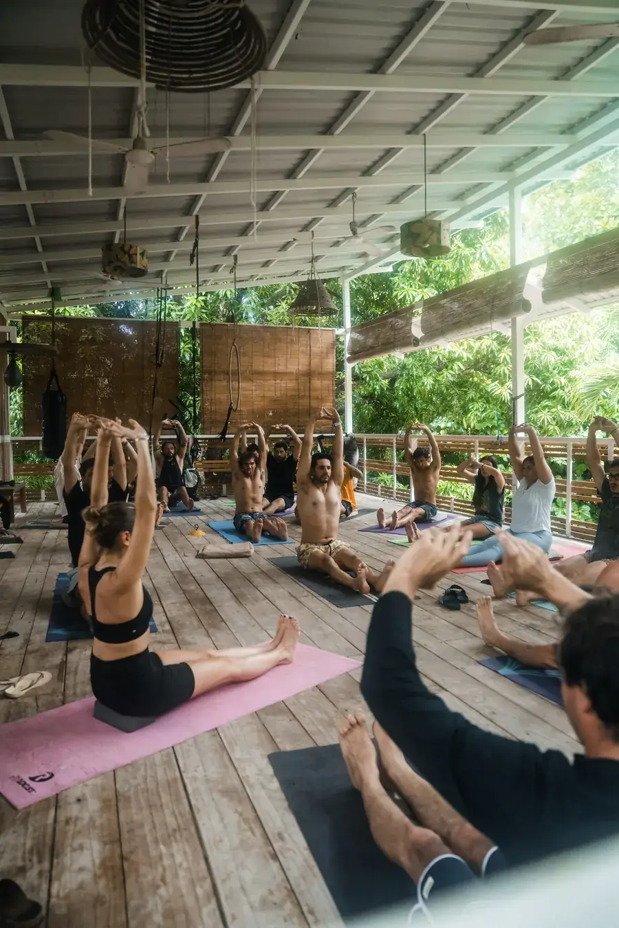 Sesión de yoga grupal en una terraza de madera