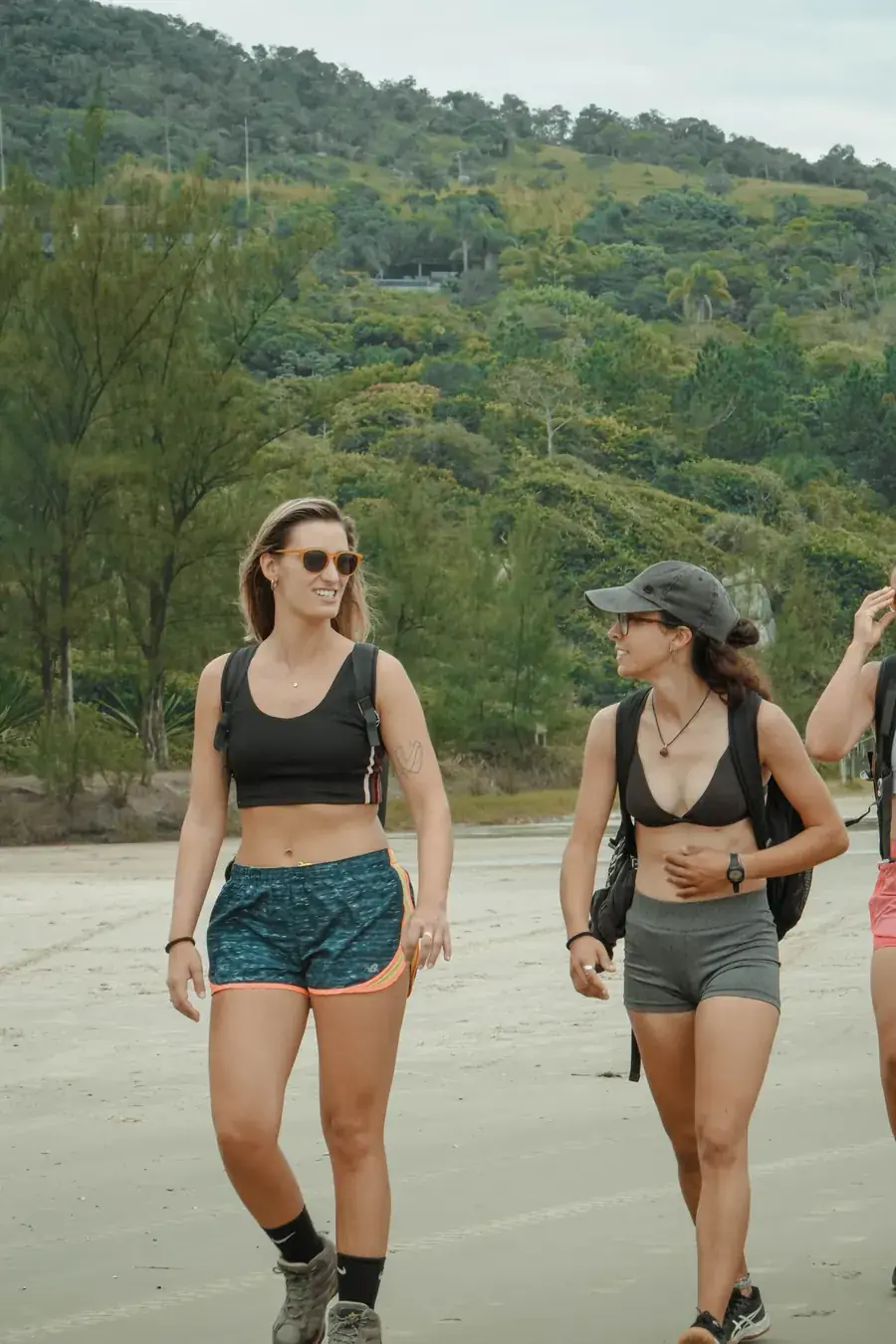Grupo caminando por la playa de Praia da Ferrugem con mochilas